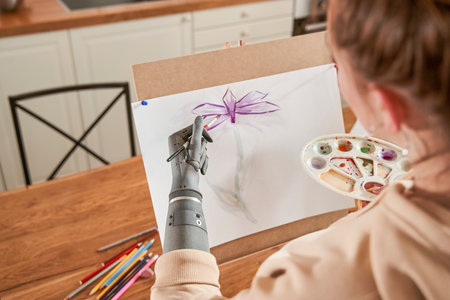 Woman artist with artificial limb standing in front of easel