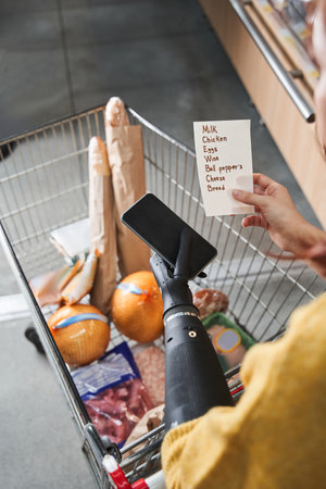 Woman with implant hand buying groceries in storeの写真素材