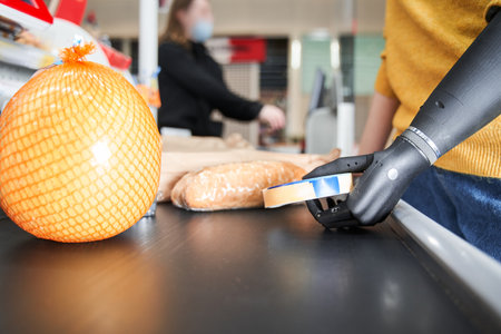 Woman lays out purchases on a moving beltの写真素材