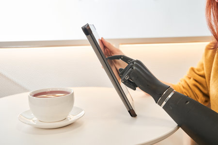 Woman with artificial limb using digital tablet