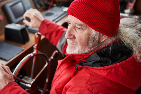 Yacht skipper standing at the steering wheelの写真素材