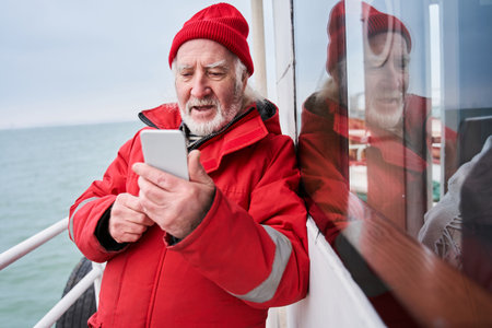 Fisherman looking at smartphone screen and calling to somebody