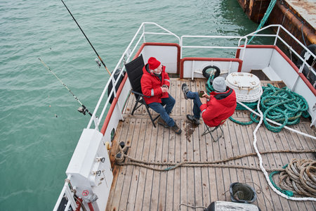 Colleagues discussing something during tea break in the deckの写真素材