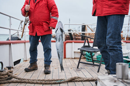 Fishermans holding their fish catch at the rodの写真素材