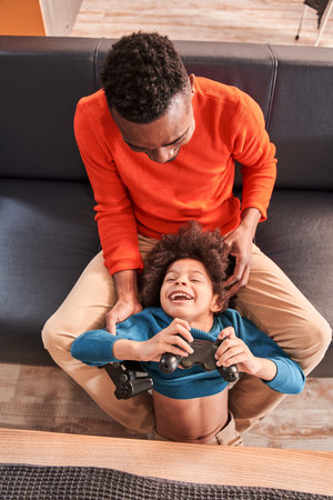 Father and son fooling around with game controllers