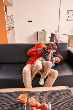 Father bonding with his son while spending time together at roomの写真素材