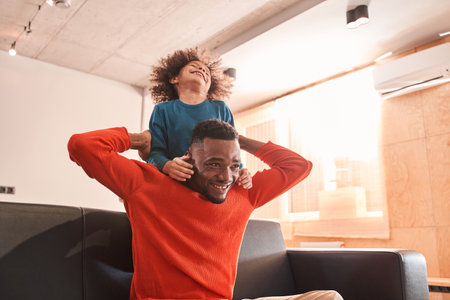 Son hugging his father at the living roomの写真素材