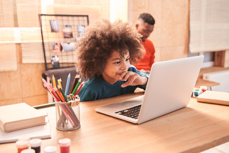 Boy sitting at online lesson in front of a laptop