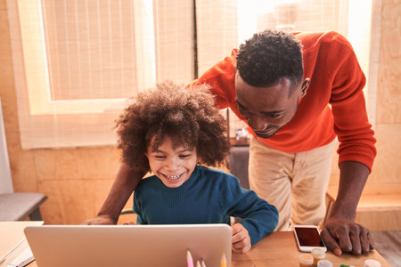 Daddy helping to his little son studying online at home