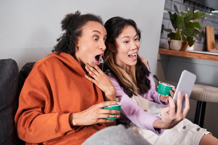 Friends taking selfie on smartphone together at home