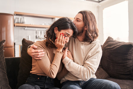 Man is calming his crying wife while holding her shouldersの写真素材