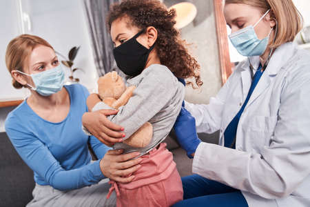 Doctor examining little patient using a stethoscopeの写真素材