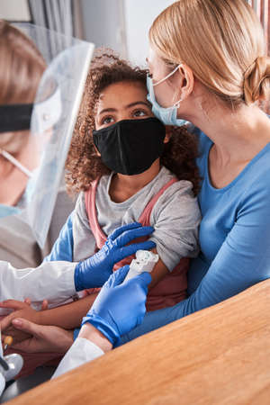 Doctor measures the temperature of a little girlの写真素材