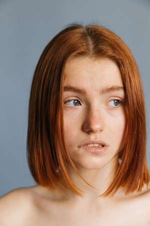 Woman biting her lips and looking sidewaysの写真素材