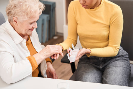 Girl giving pills to the senior woman
