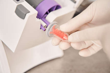 Dentist holding fragment of impression material mixing machine
