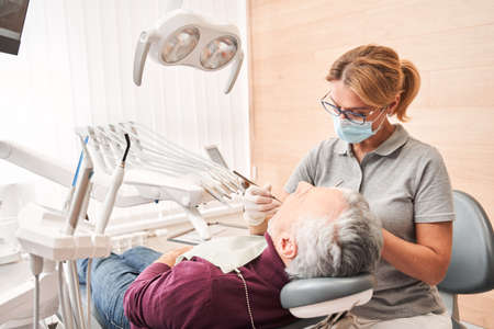 Skillful confident dentist working at her office