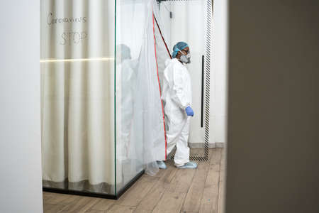 Doctor wearing protective equipment comes out of isolation unitの写真素材