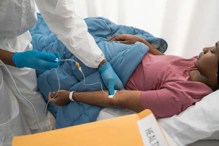 Doctor making dropper with saline for his sick patientの写真素材