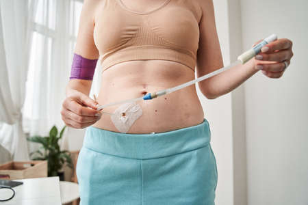 Woman adjusting tube of her glucose meterの写真素材