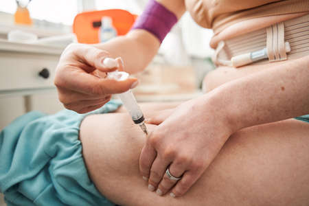Woman with syringe making insulin injectionの写真素材