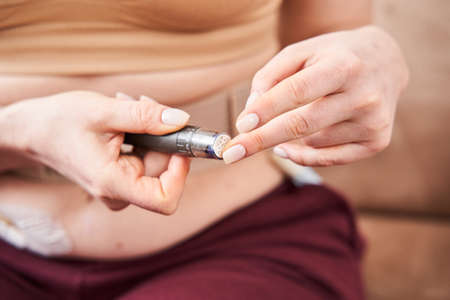 Woman holding portable glucose meter electronic deviceの写真素材