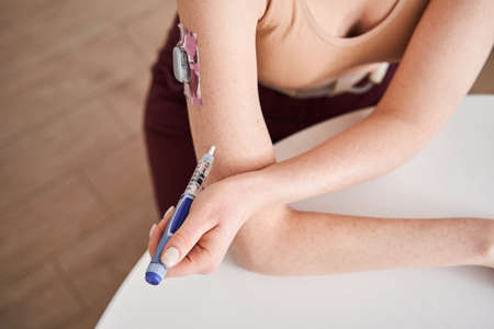 Patient giving insulin injection into the hand
