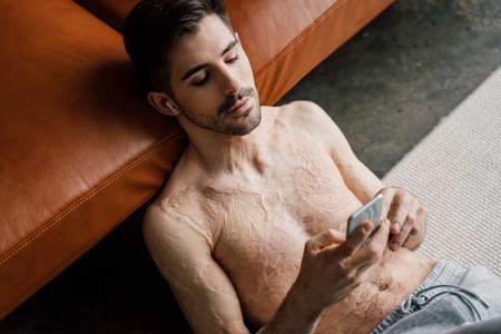 Happy young man resting at home while listening musicの写真素材