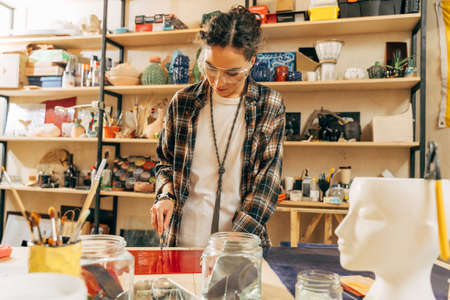 Young artist cutting glass with the blade for the new mosaicsの写真素材