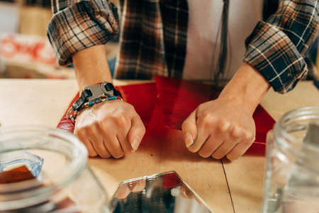 Artist breaks glass with hands while preparing mosaics at her modern studio