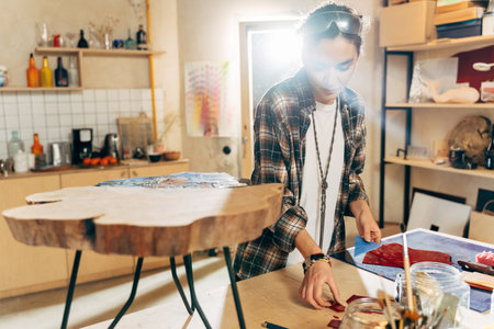 Concentrated designer making mosaic at her studio while working with glassの写真素材