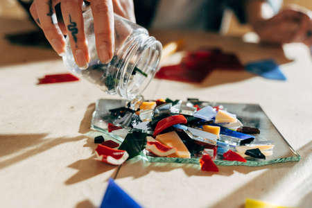 Designer or artist pouring glass samples from the jar while workingの写真素材