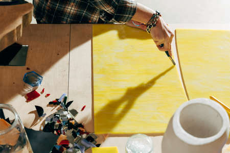 Female artist working with blade at the new mosaicsの写真素材