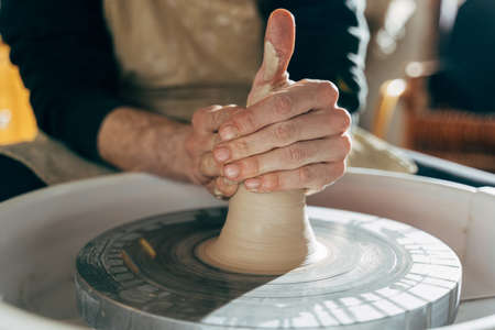 Potters hands shaping a bowl on the spinning by clay, mold, crockery, earthenwareの写真素材