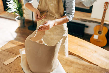 Serious clay artist preparing for handicraft lesson in studioの写真素材