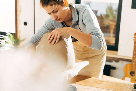 Serious clay artist preparing for handicraft lesson in studioの写真素材