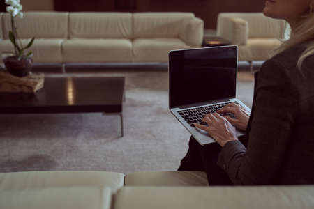 Hard-working woman using her laptop to work distantly during a layoverの写真素材