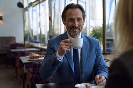 Little coffee date with a charming well-dressed manの写真素材