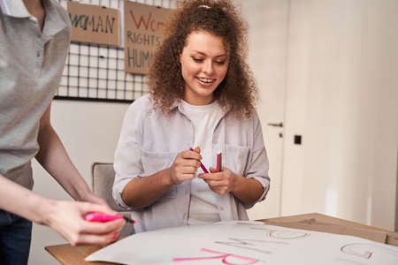 Girl looking at the handmade poster about feminism while preparing to the rally
