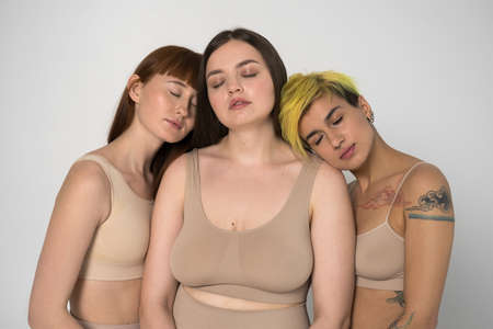 Three diverse girls posing with eyes closed at the studioの写真素材