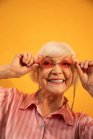Woman wearing stylish sunglasses smiling and feeling young