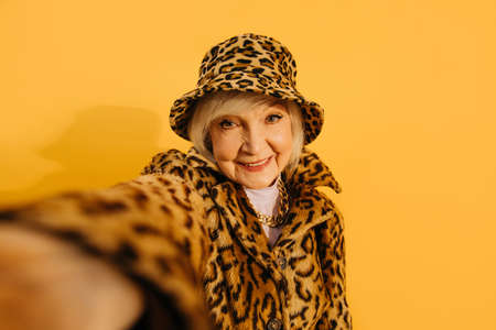 Woman wearing total leopard look taking selfie while spending time at the studioの写真素材