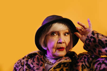 Woman dressed in fashionable outfit enjoying life in old ageの写真素材