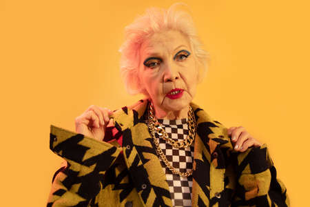 Woman posing at the studio with yellow wall at the background
