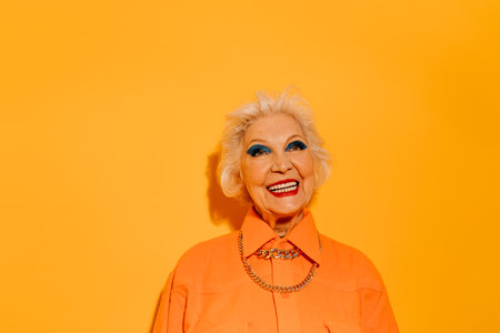 Woman dressed in stylish coat posing at the studio with wide smileの写真素材