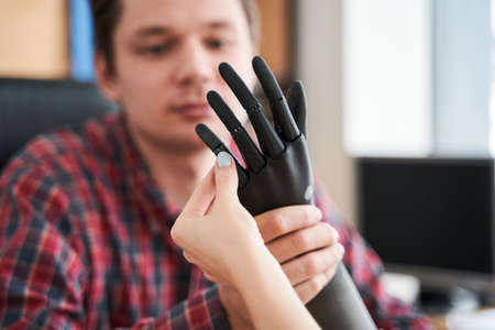Engineer showing a new artificial limb for his client or patient