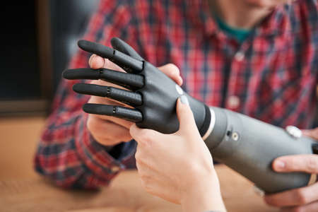 Engineer showing a new artificial limb for his client or patient