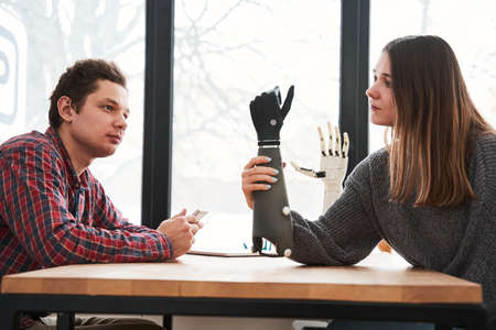 Woman looking critically and thoughtfully at the bionic prosthesis limb
