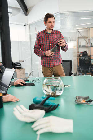 Prosthetist holding prosthetic hand and making presentation of it