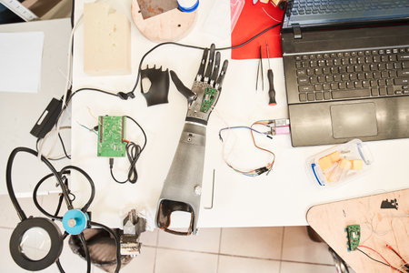 Bionic hand laying at the table while people workingの写真素材